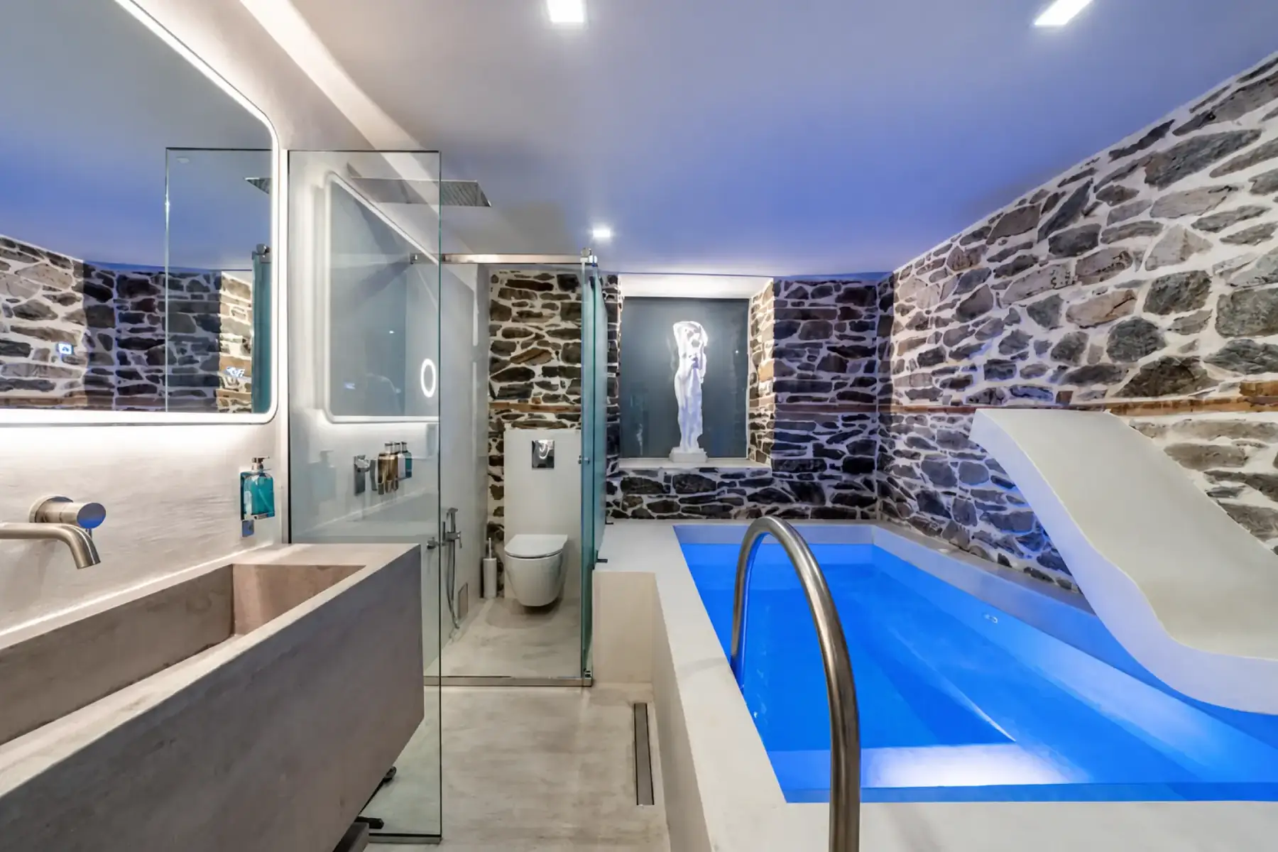 Bathroom with a walk-in shower, stone basin and an illuminated private plunge pool